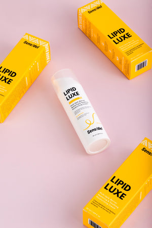 Lipid Luxe skincare product with yellow boxes on a pink background